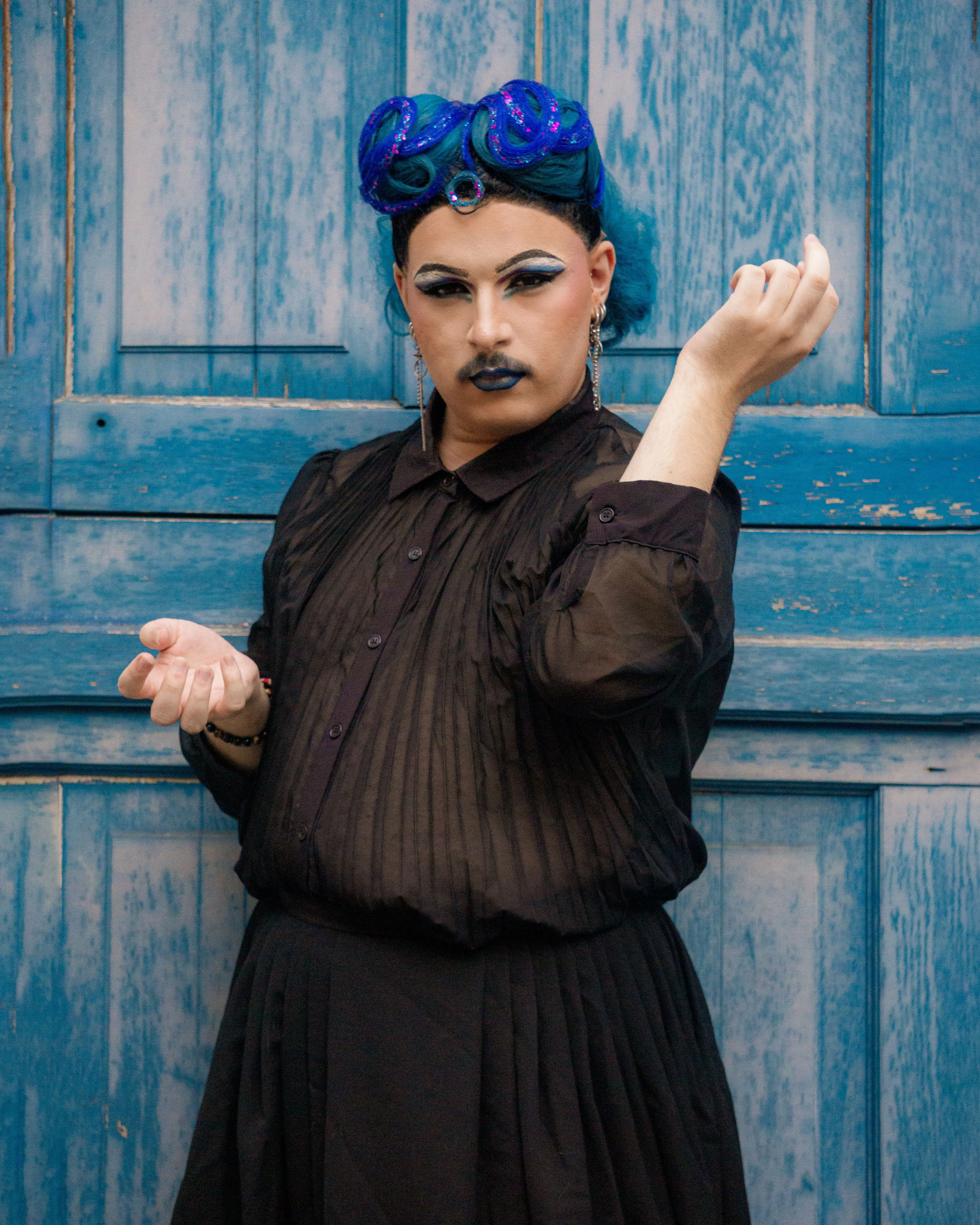 Portrait artistique maquillage et perruque bleue devant une porte bleue — photographie par Maëlle Vétois